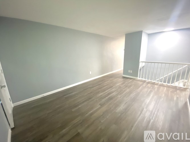 A room with wooden flooring and a white staircase.