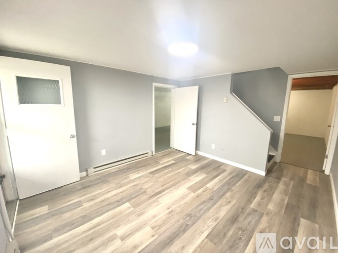 A room with wooden flooring and white walls.