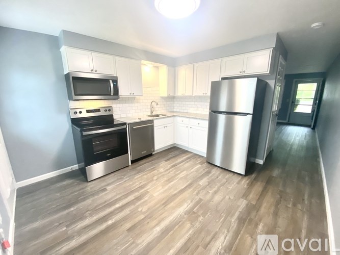 A kitchen with a stainless steel refrigerator, oven, and microwave.