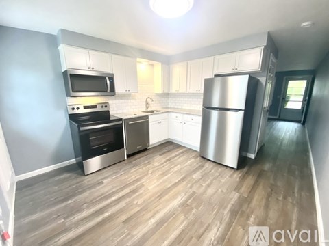 A kitchen with a stainless steel refrigerator, oven, and microwave.