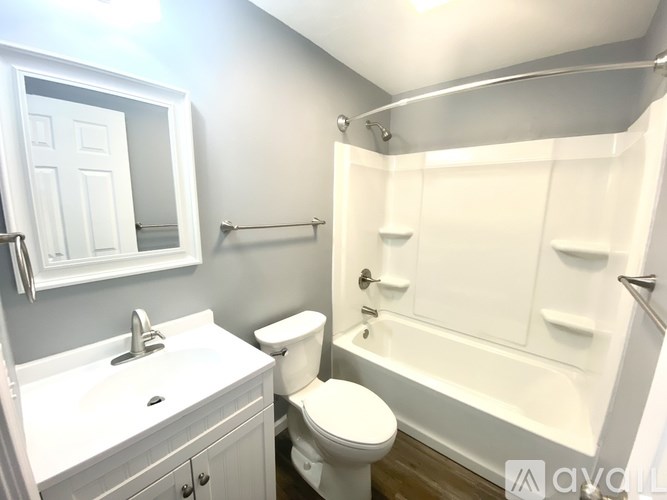 A white bathroom with a toilet, sink, and bathtub.