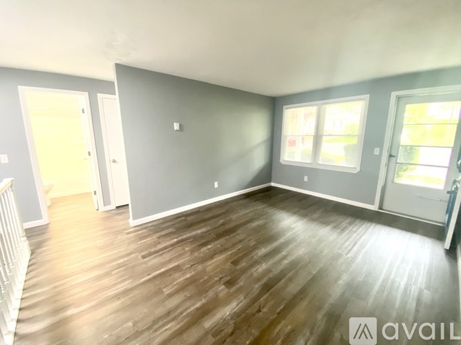A room with wooden flooring and two doors.