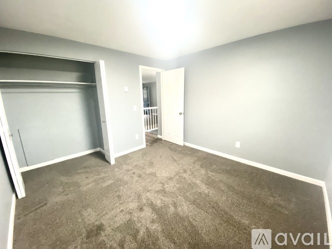 A room with a carpeted floor and a doorway leading to another room.