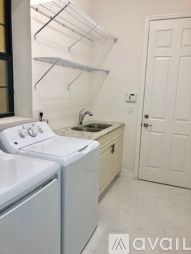 A small white laundry room with a washer and dryer.