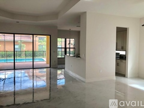 A spacious living room with a pool visible through the glass doors.