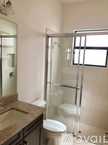 A bathroom with a toilet, sink, and shower.