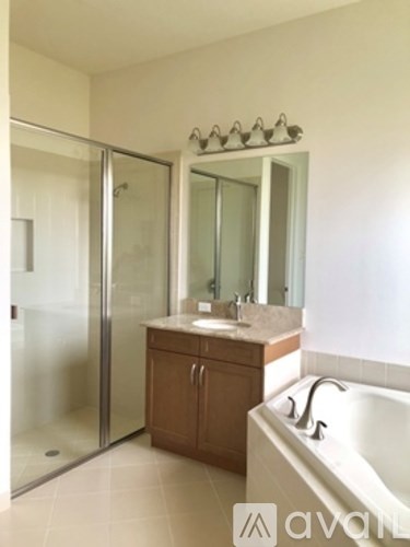 A bathroom with a tub, sink, and shower.