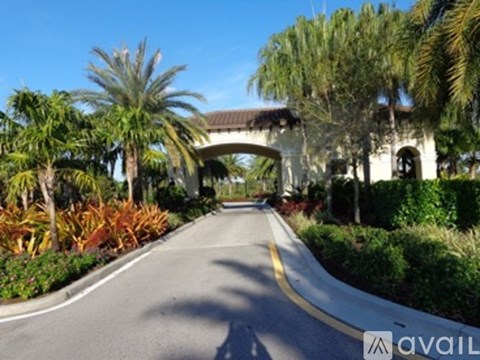 A road with a yellow line in the middle and a white archway on the right.