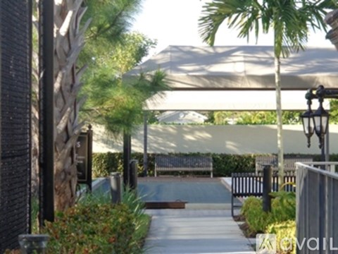 A walkway with a lamp post and a tree trunk on the left.