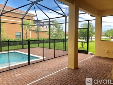 A patio with a pool and a glass wall.