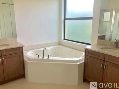 A bathroom with a large tub and a window.