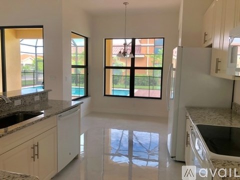 A kitchen with white cabinets and a granite countertop.