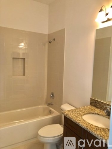 A white toilet sits next to a bathtub in a bathroom.