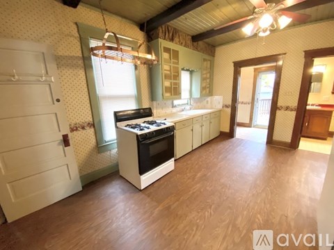 A kitchen with a white stove top oven and a white counter top.