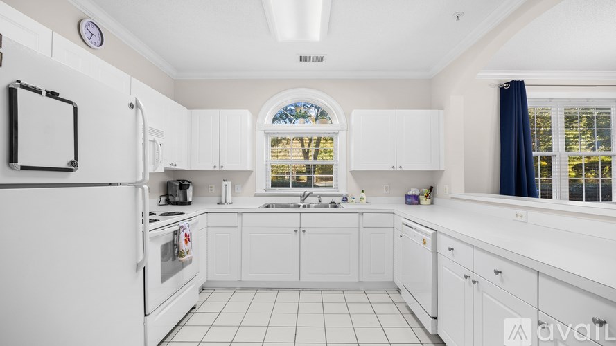 A kitchen with white cabinets and appliances.