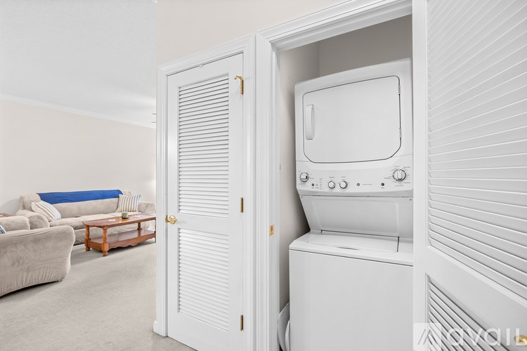 A white arcade machine sits in a white cabinet in a living room.