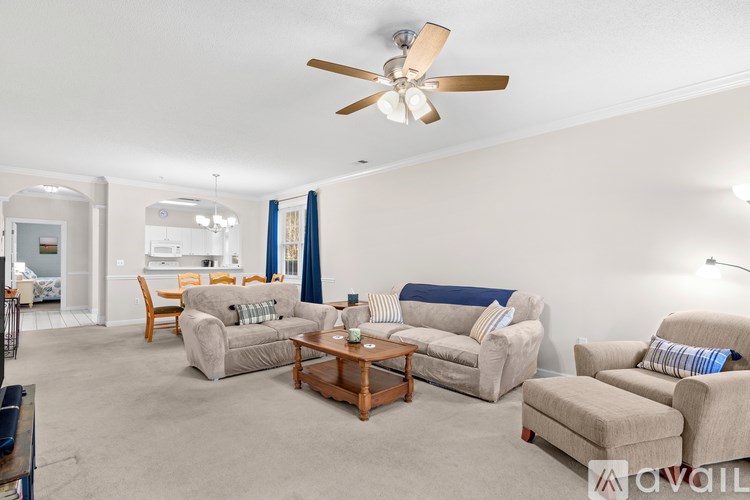 A living room with a ceiling fan and furniture.
