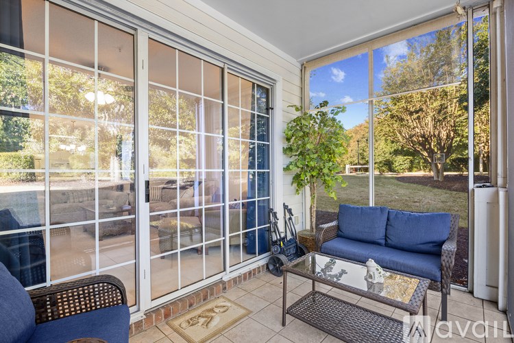 A patio with a sofa and a table with a glass top.