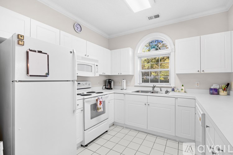 A white kitchen with a stainless steel oven and microwave.