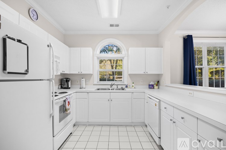 A kitchen with white cabinets and appliances.