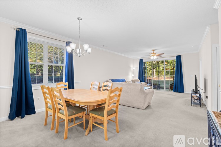 A dining room with a wooden table and chairs.