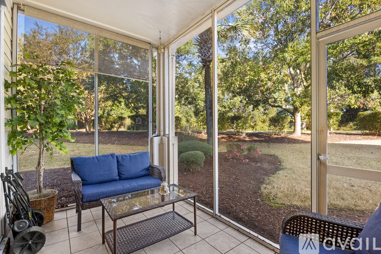 A patio with a sofa and a glass table.