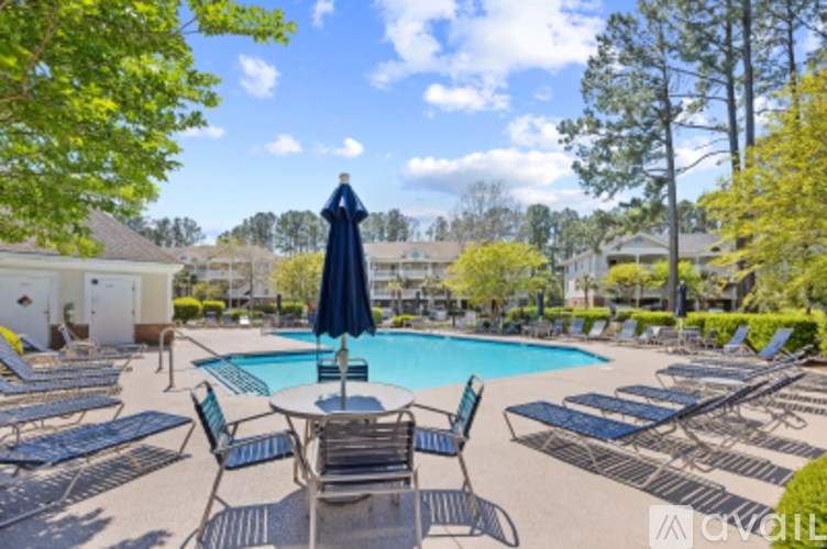 A pool area with chairs and a statue in the middle.