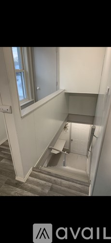 A stairwell with a light grey carpeted floor and white walls.