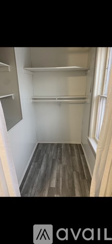 A room with wooden flooring and white walls.