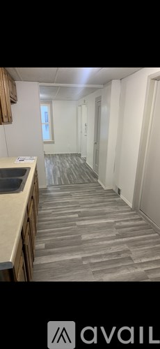 A hallway with a tiled floor and a door on the right.