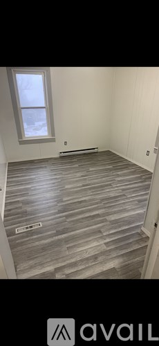 A room with wooden flooring and a window.