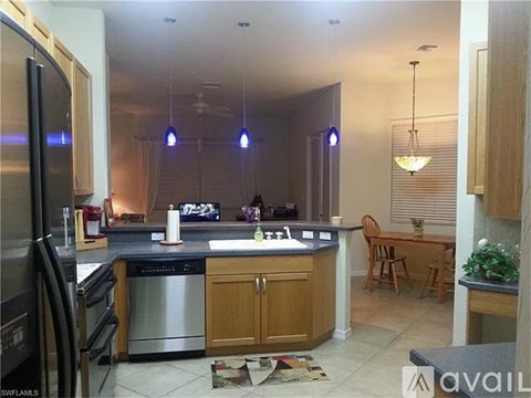 A kitchen with a refrigerator, oven, and sink.