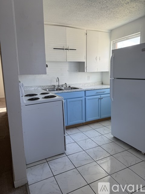 A kitchen with white appliances and blue cabinets.
