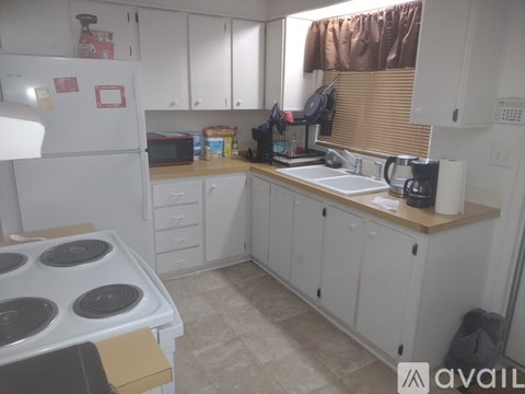 A kitchen with white cabinets and a white refrigerator.