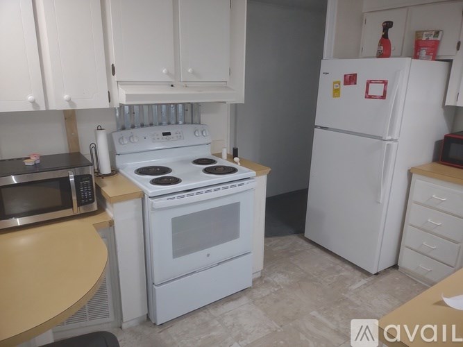 A kitchen with a white stove and refrigerator.