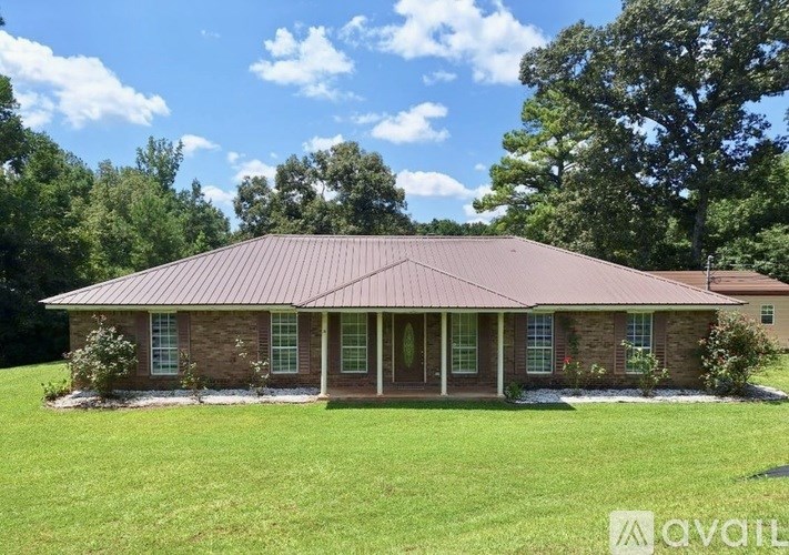 A house with a red roof and a green lawn.