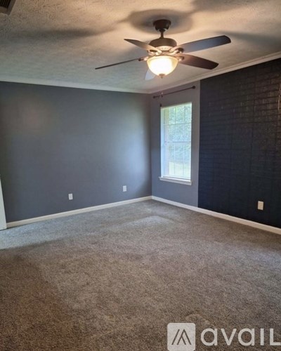 A room with a ceiling fan and carpeted floor.