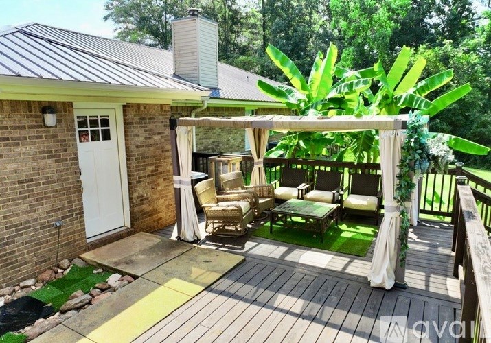 A wooden deck with a white door and a white canopy.