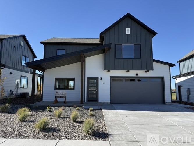 A modern house with a grey garage door and a white front door.