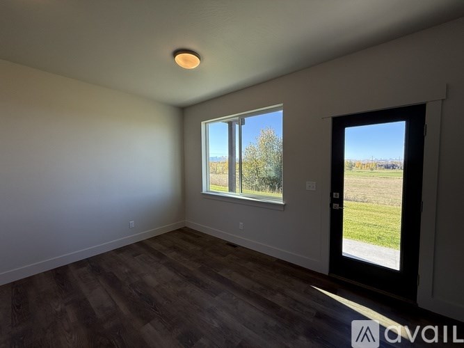A room with a large window and a door leading outside.