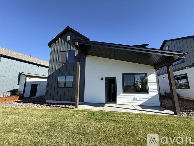 A modern house with a white and dark grey exterior is available for purchase.