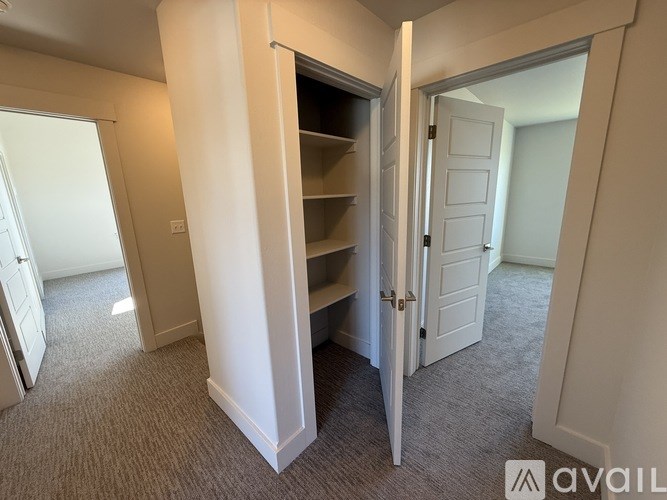A room with a carpeted floor and a white door.