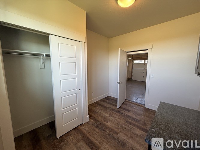 A room with a white door and a grey countertop.