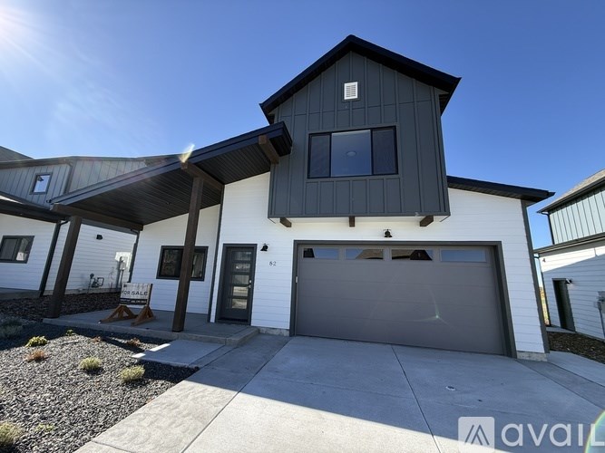 A modern house with a black and white exterior and a large garage door.