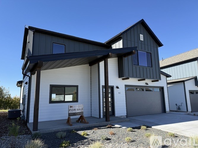 A modern house with a black and white exterior is for sale.