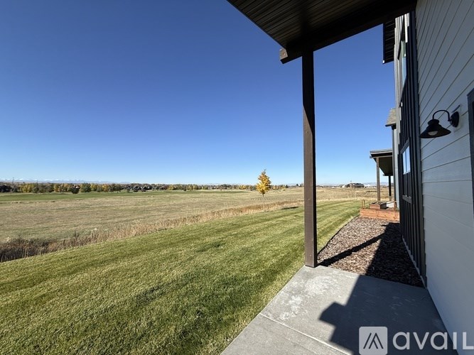 A house with a view of a field and a clear blue sky.