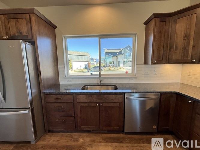 A kitchen with wooden cabinets and a window showing a building outside.