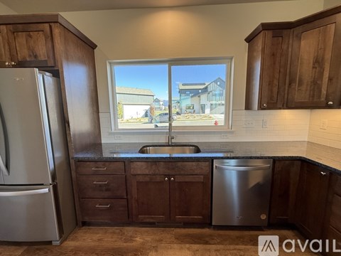 A kitchen with wooden cabinets and a window showing a building outside.