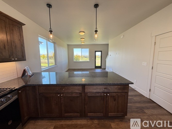 A kitchen with dark wood cabinets and a granite countertop.