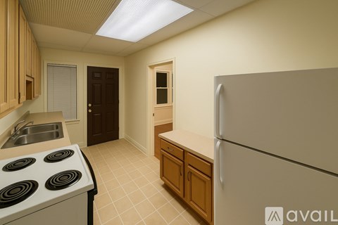 A kitchen with a white stove top oven and a white refrigerator.